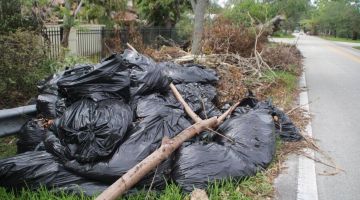 Residents toss their garbage into the storm debris